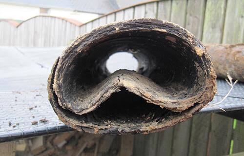 Cut section of pitch fibre pipe with the invert folded upward into the bore, leaving a narrow waterway