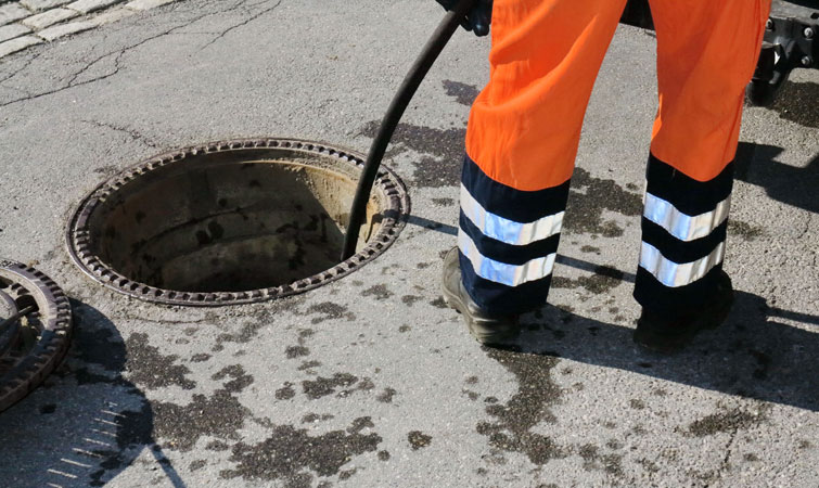 Exjet engineer unblocking drain and sewer manhole in the road